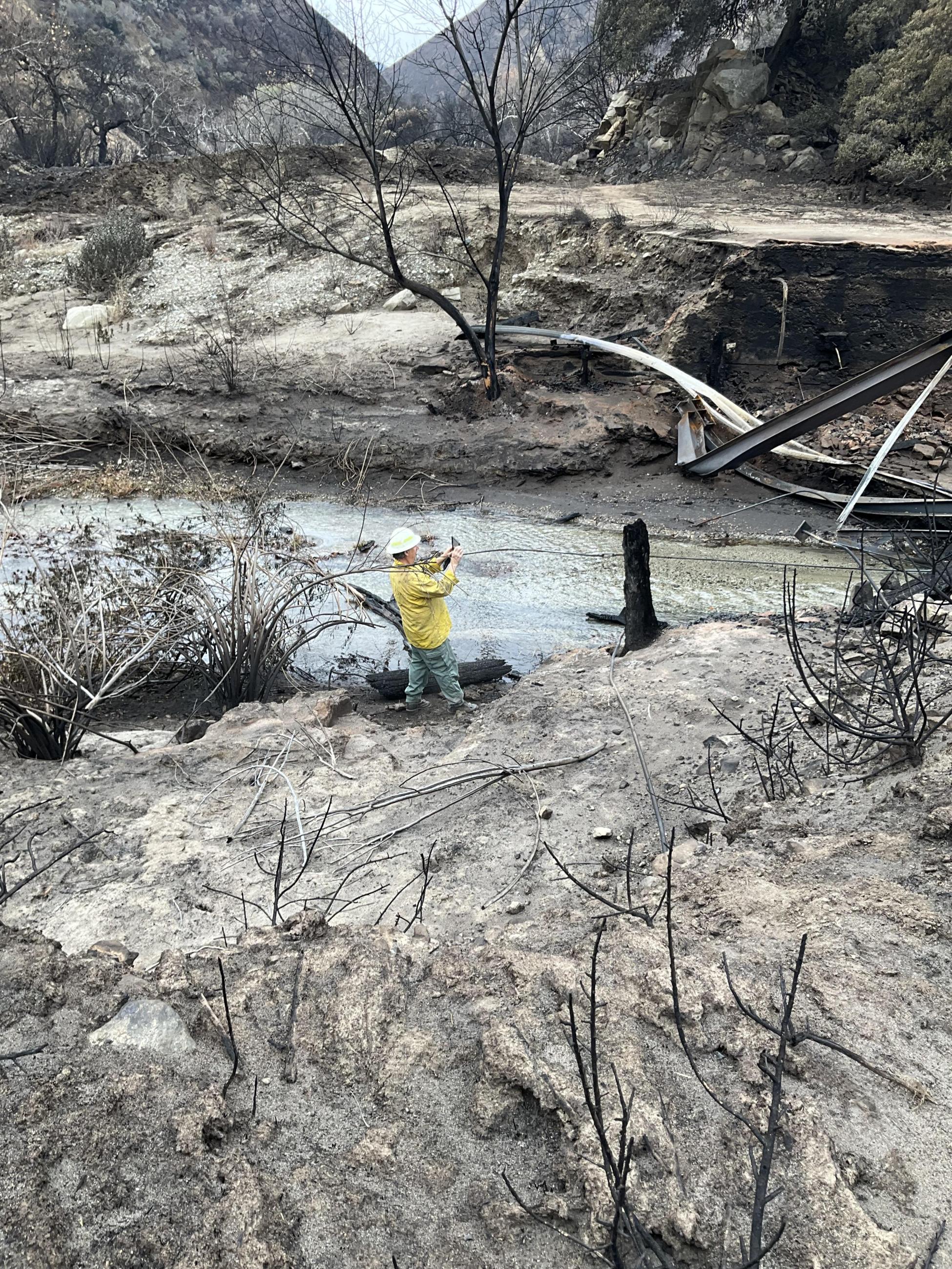 Photo Image Showing BAER Hydrologist Andy Stone Assesses Burned Bridge and Evaluates Stream Conditions in Hughes Burn Area