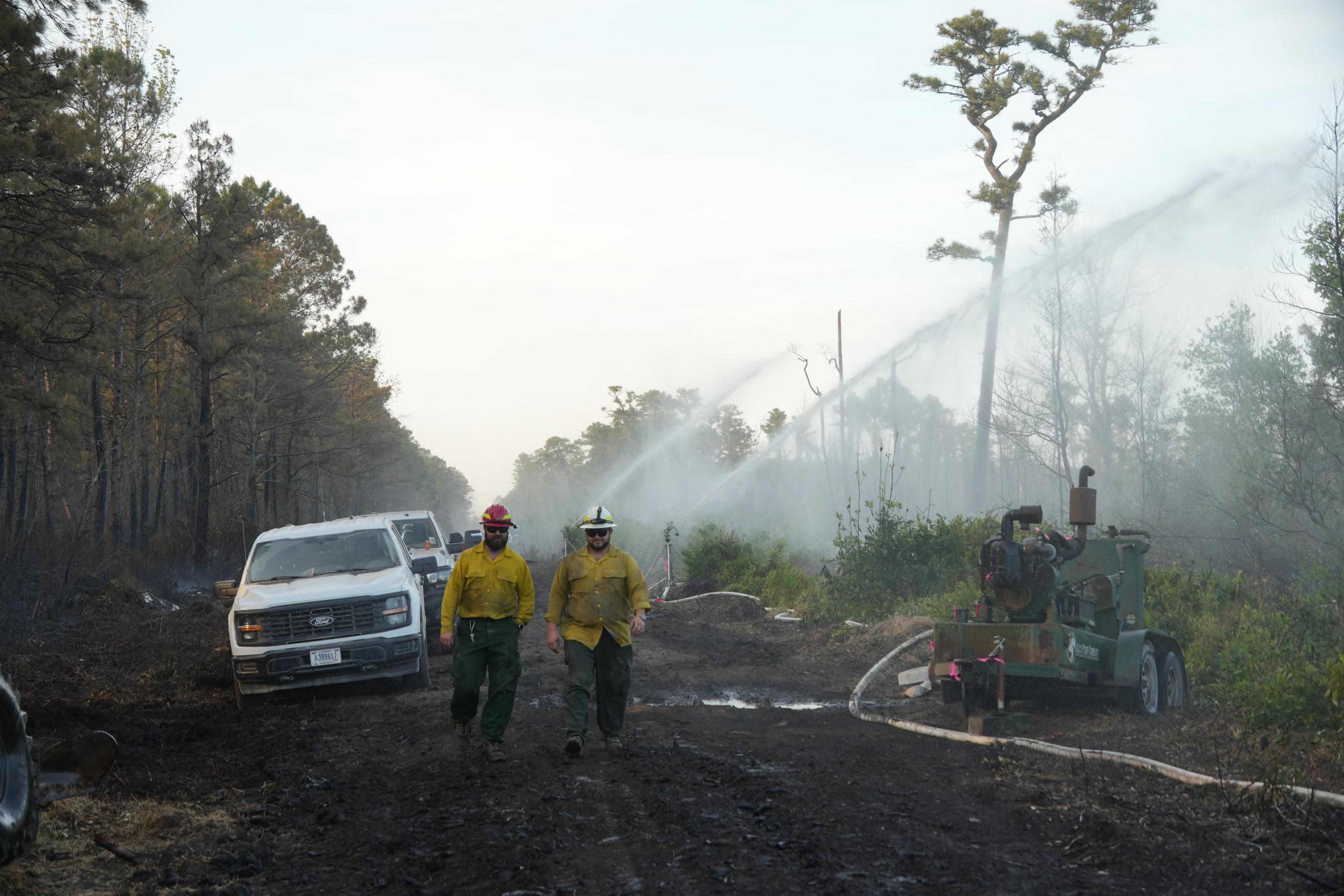 Firefighters walking along containment line
