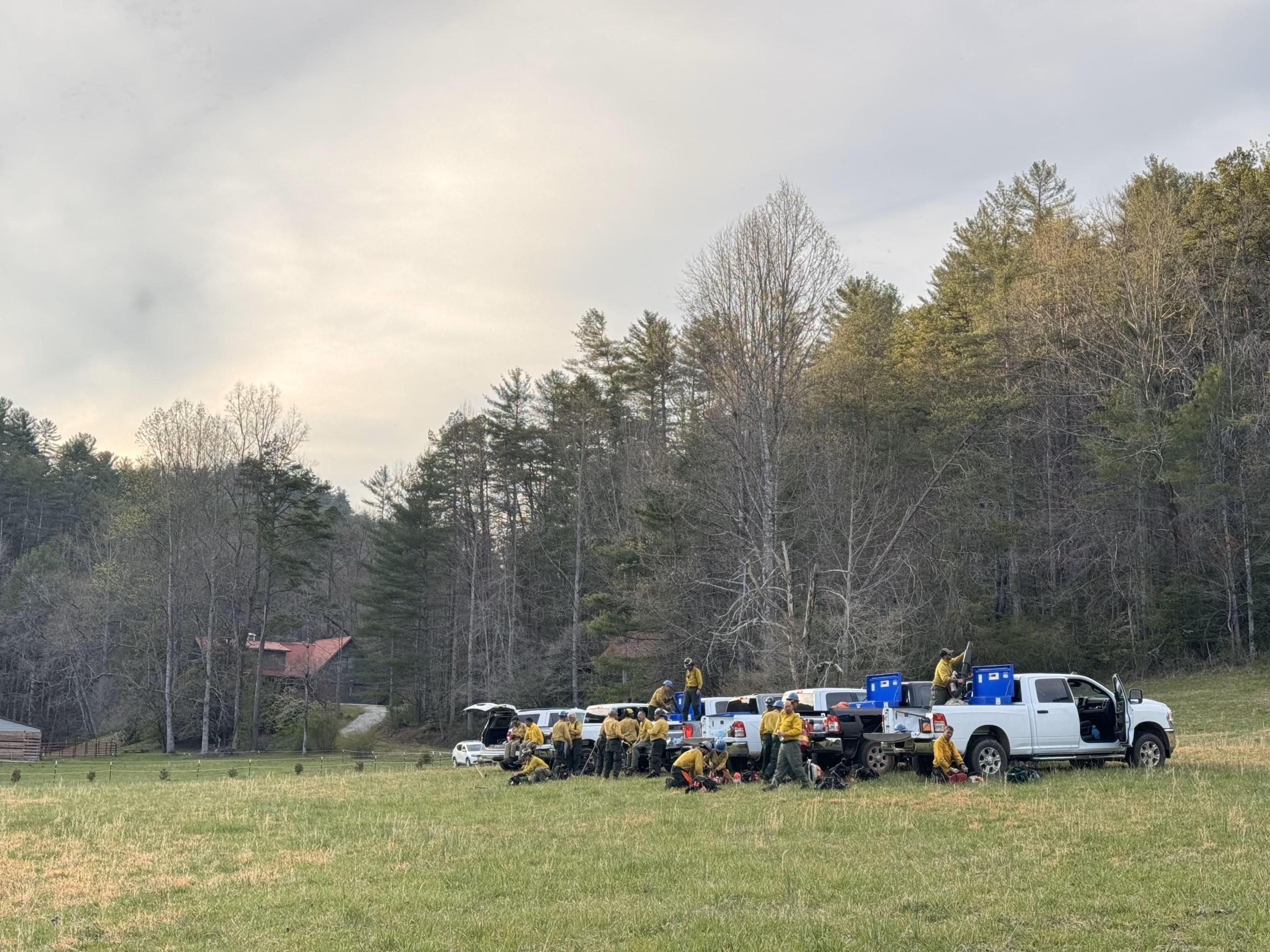 Photo showing a 20 person fire crew unloading their trucks before shift starts
