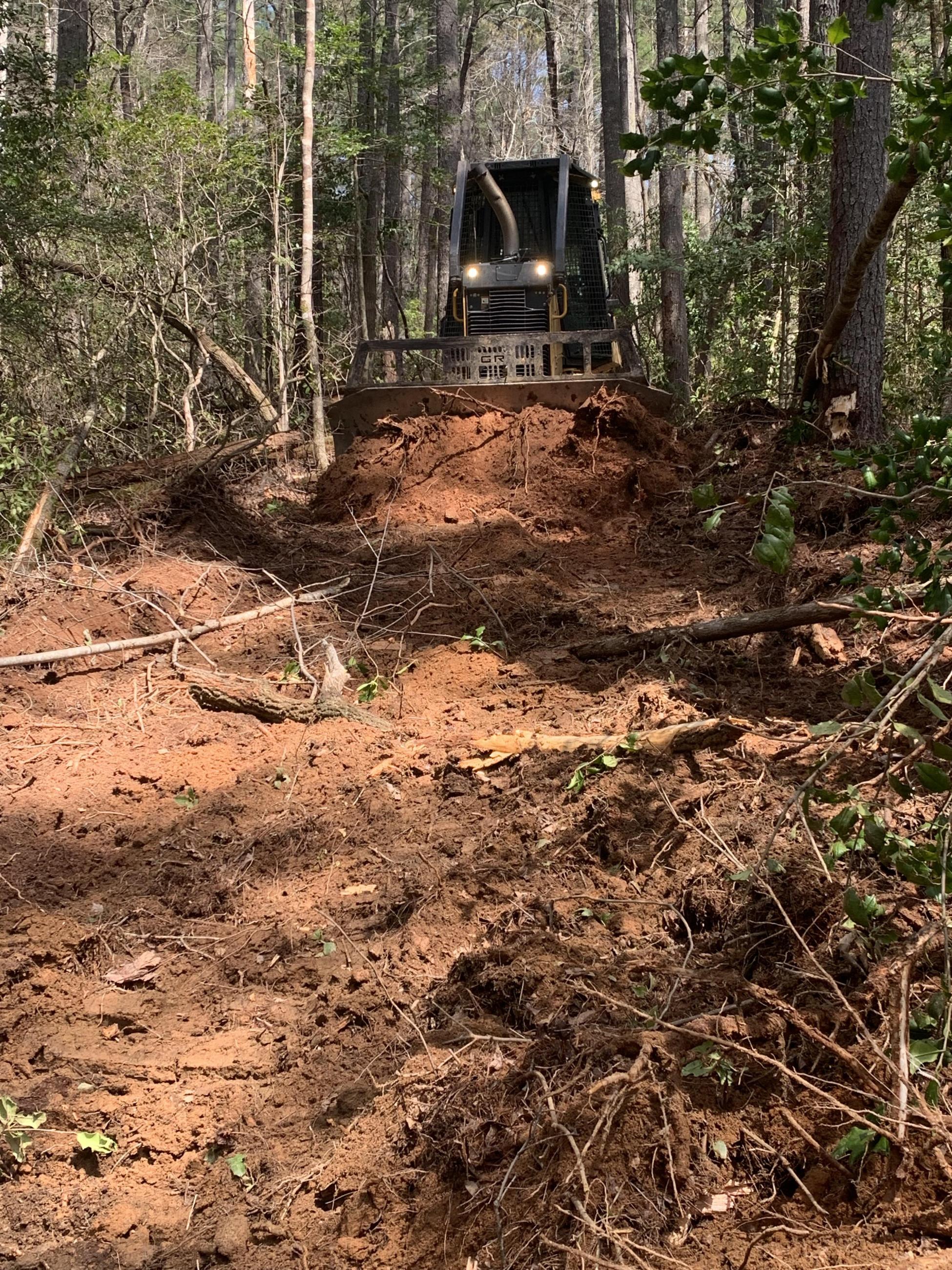 Photo of a dozer pushing dirt to improve a fire line.