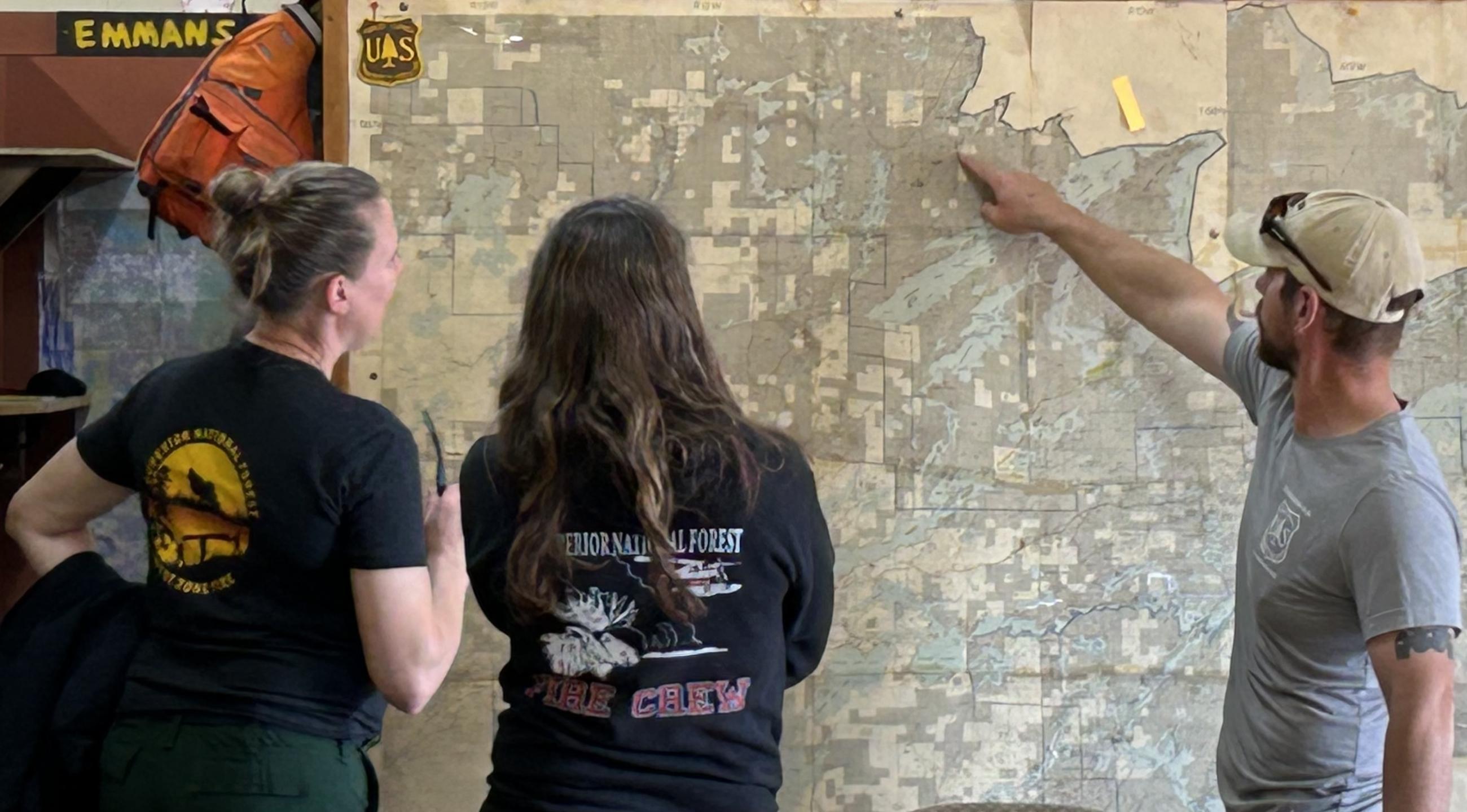 Three staff looking at a map
