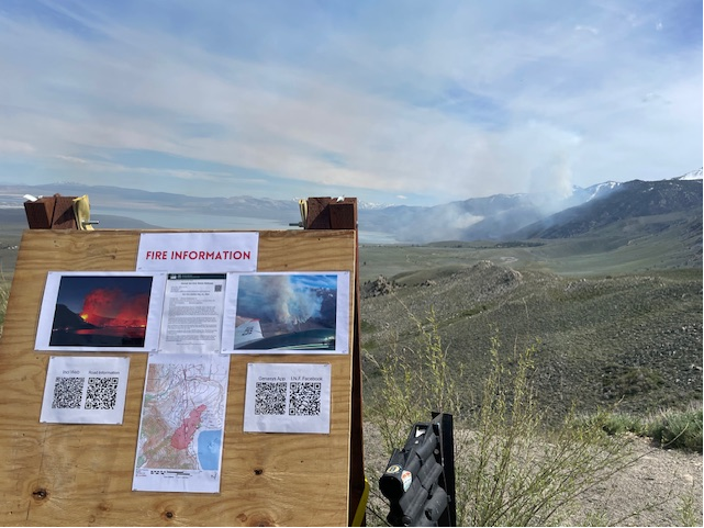wooden board sign, mountains, smoke, sky