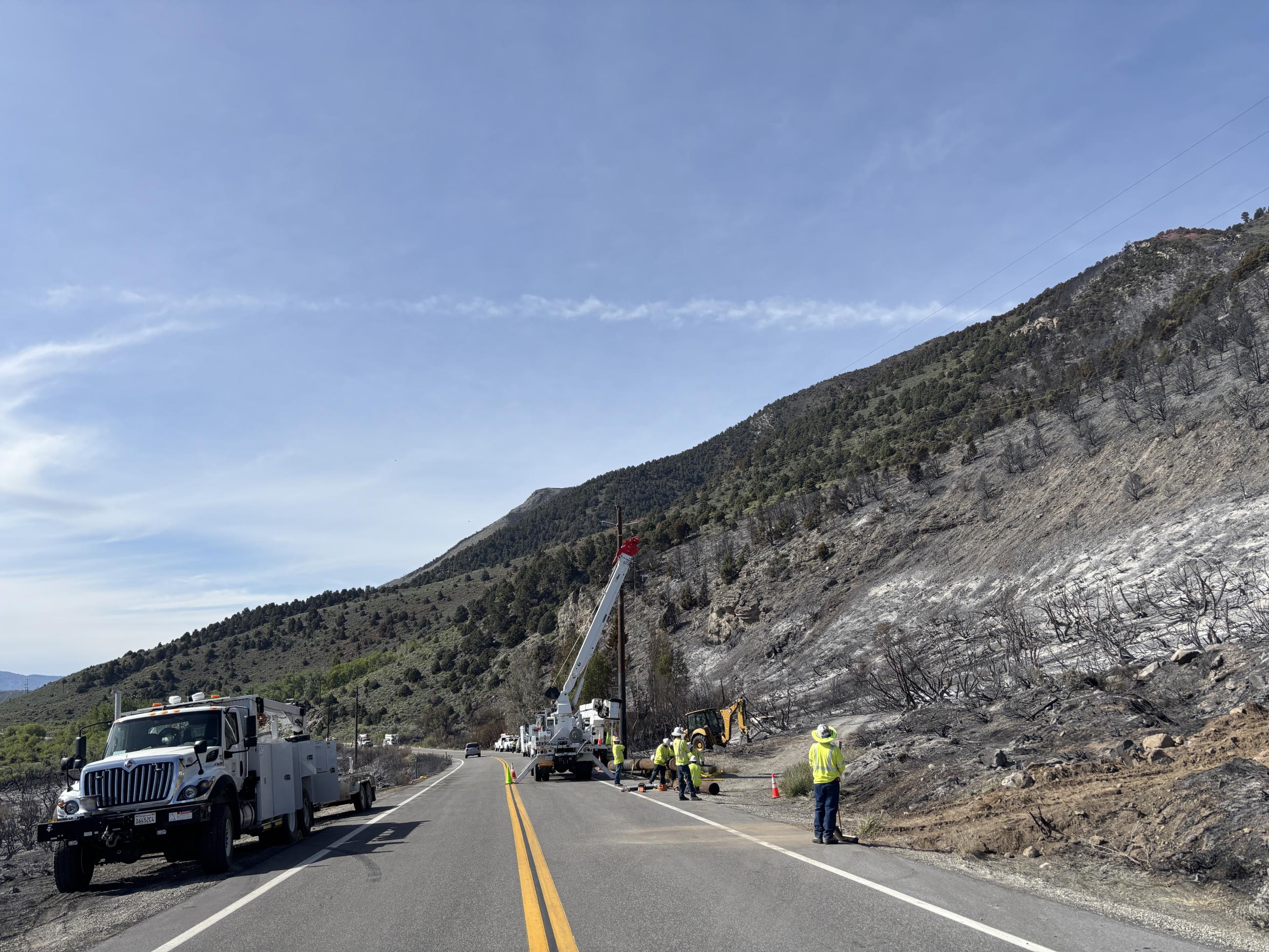 Utility workers from SCE work to install new power poles near Hwy 395