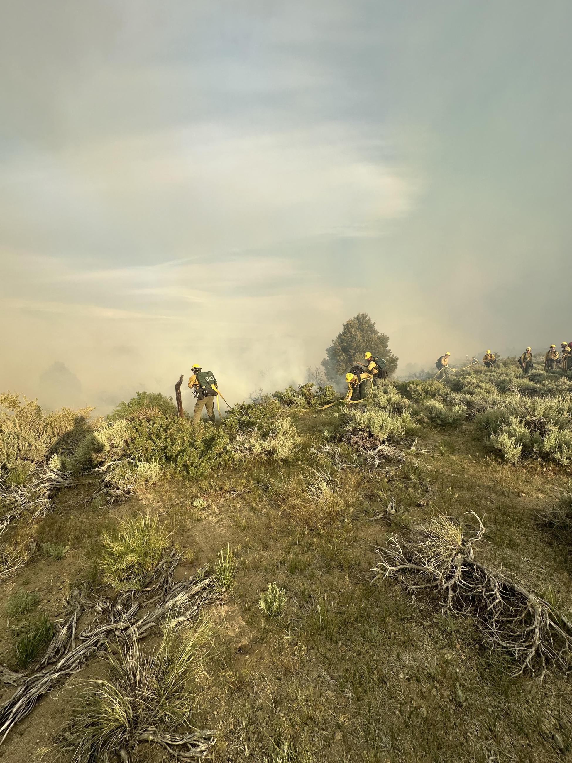Firefighters using firehose to attack the flames of the Inn Fire