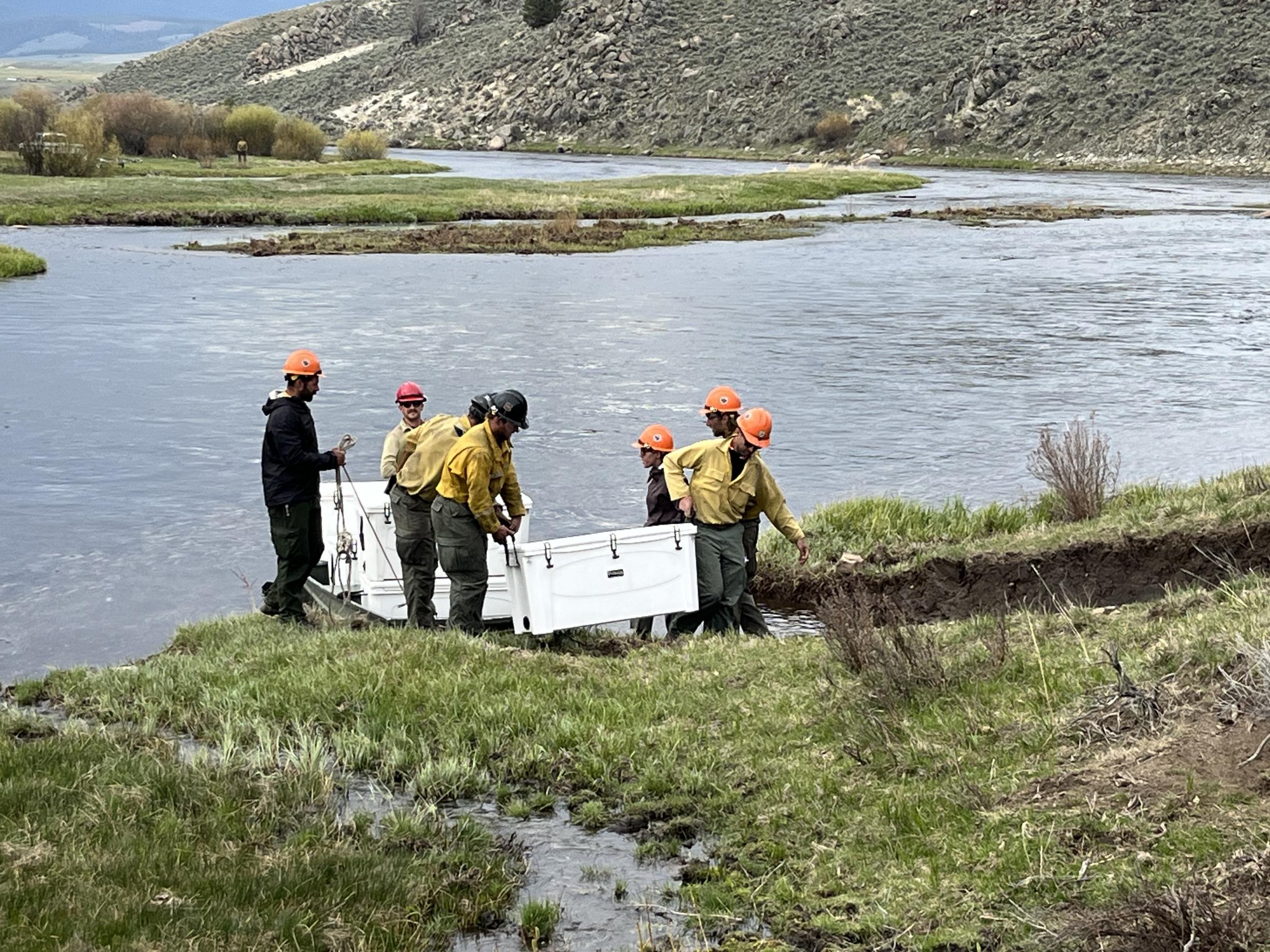 Firefighters unloading coolers out of a boat