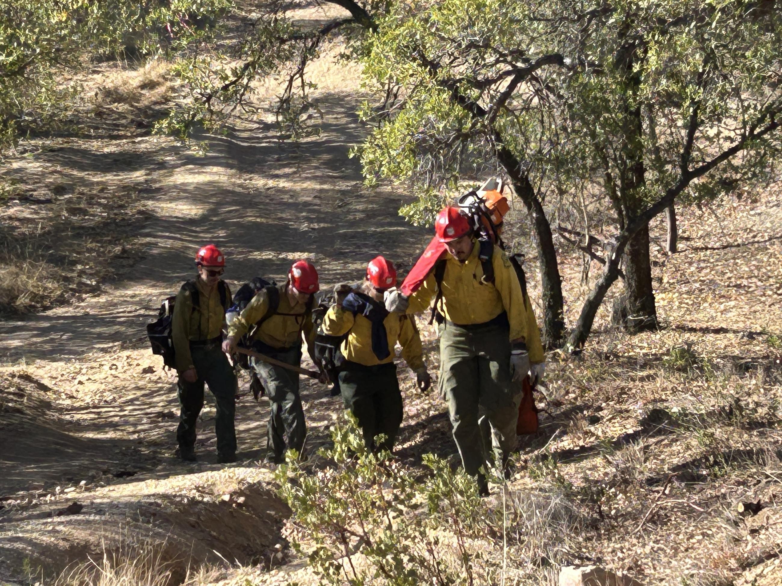 Firefighters hiking with saws