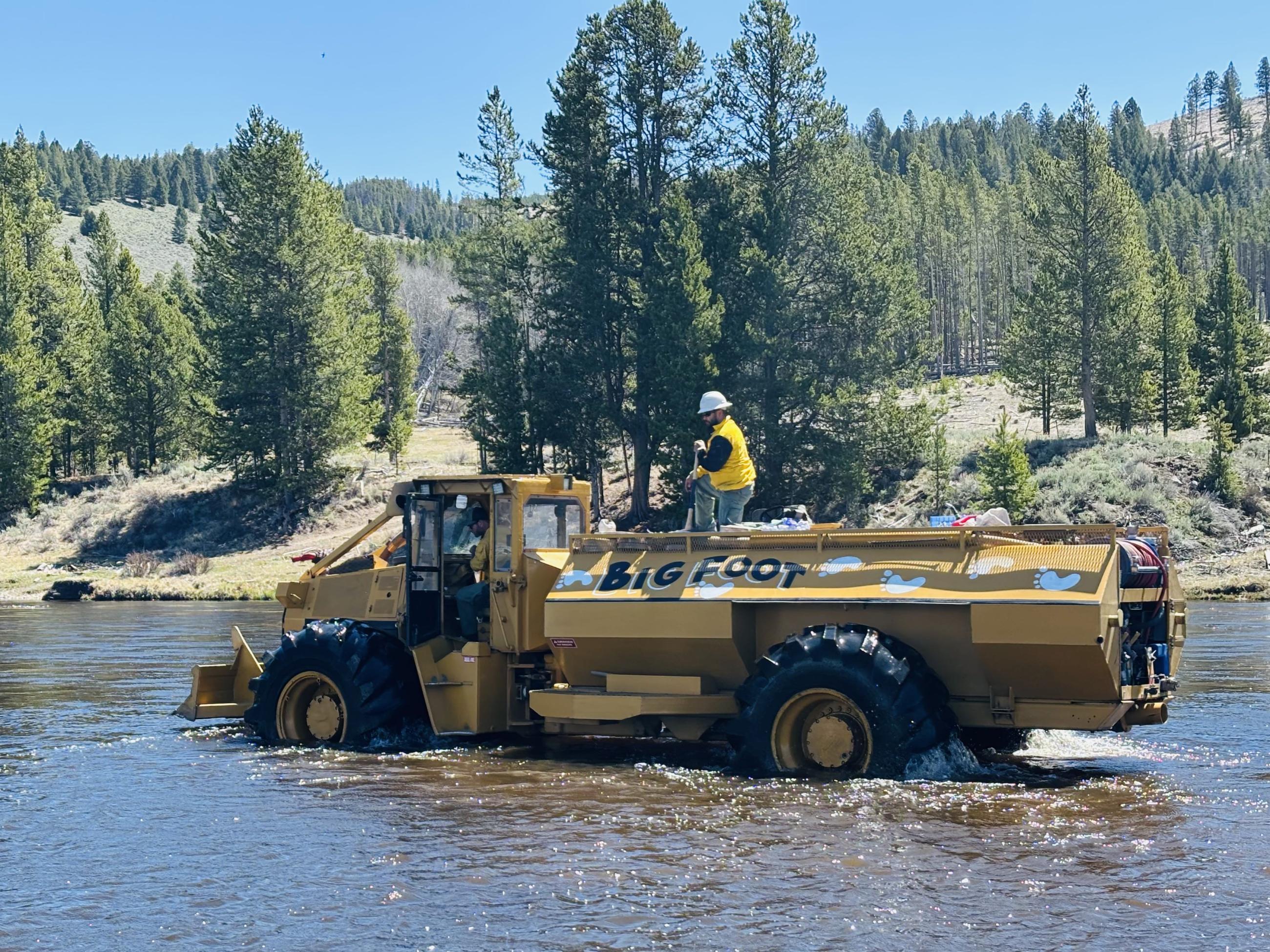Skidgen in the river with firefighters riding in it 