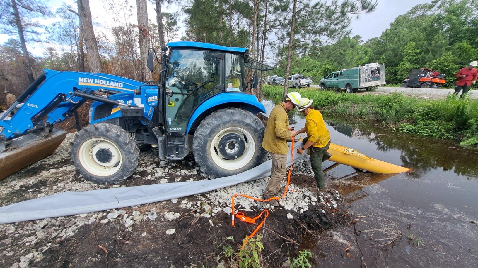 Firefighters attach hose to tractor pump