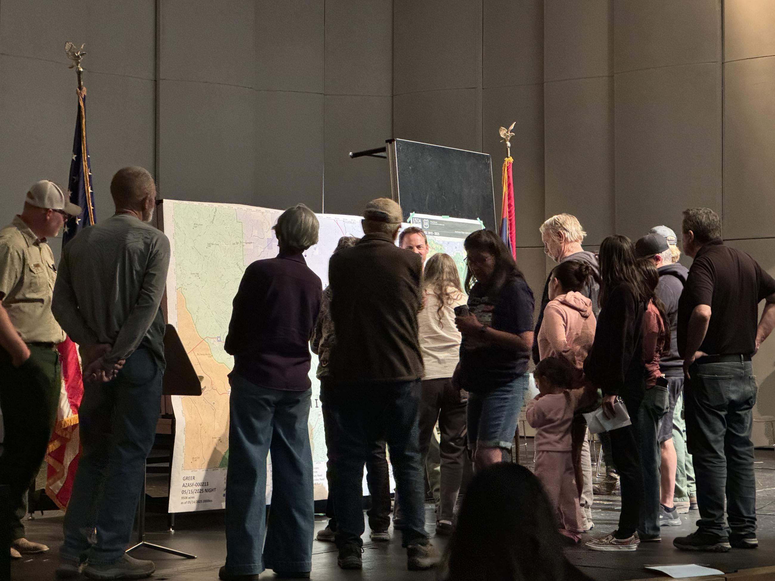 Members of the public gathering around a map of the fire.