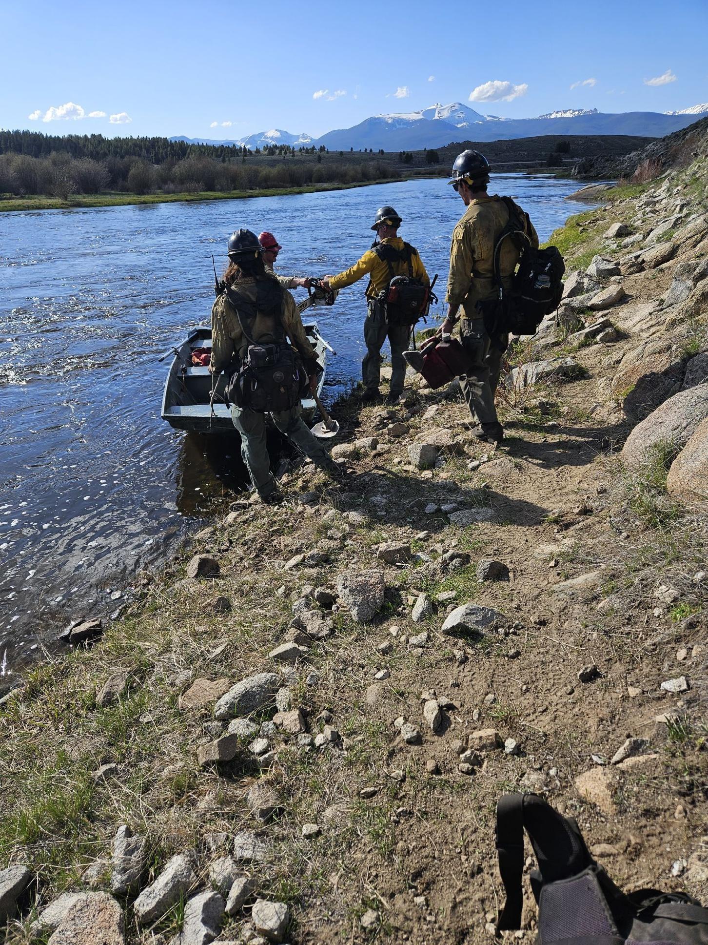Firefighters crossing the Bighole River on boat