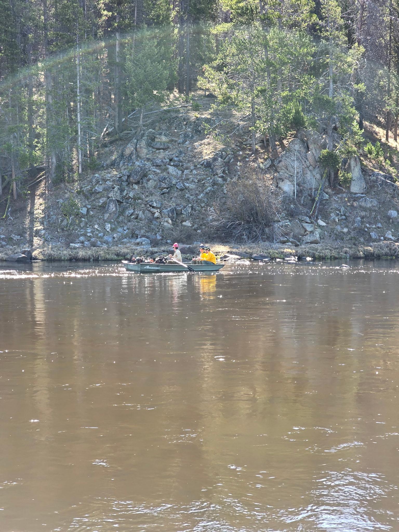 Firefighters in a boat going across a river 