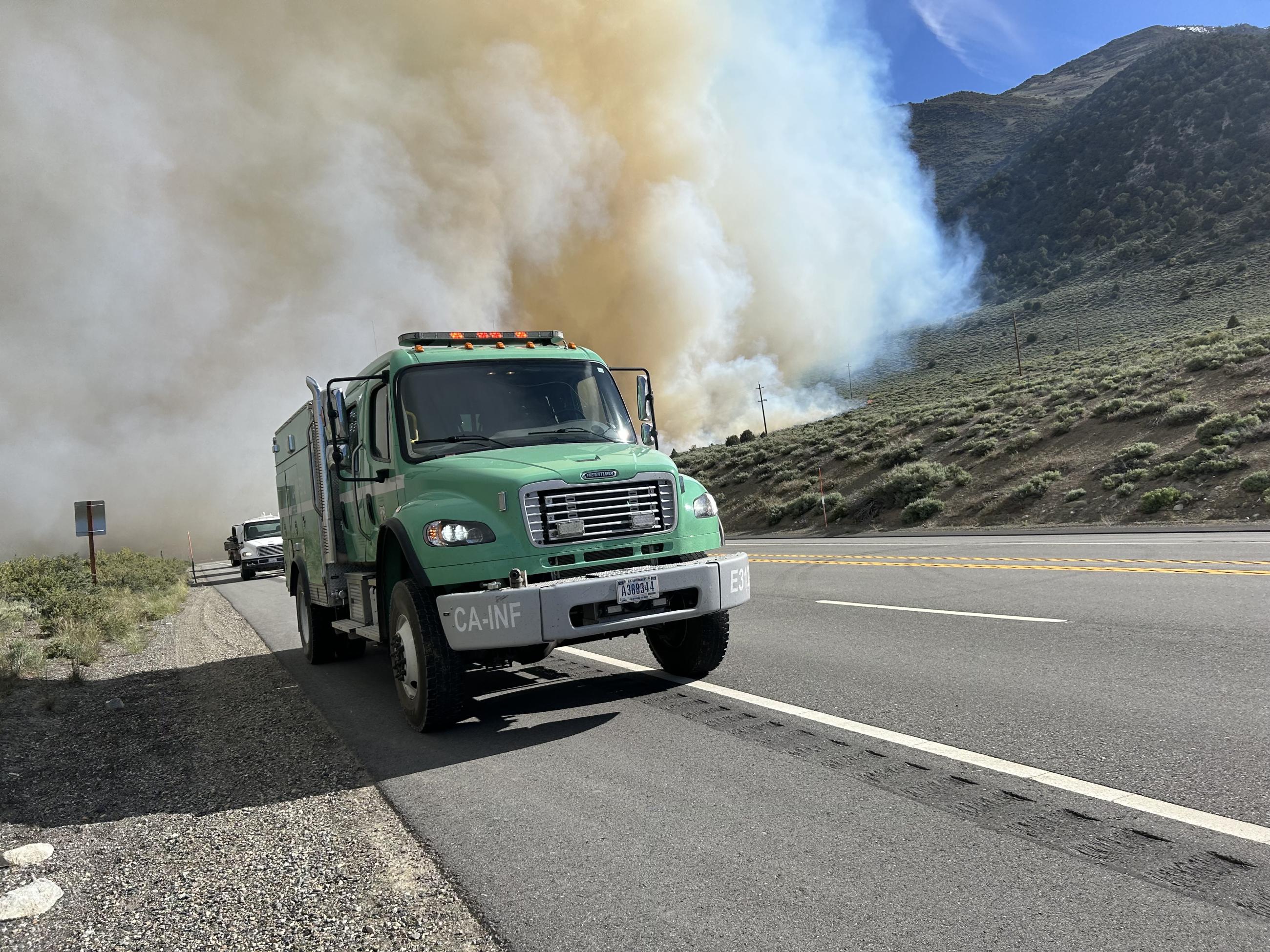 green fire engine, highway, smoke, brush, mountain