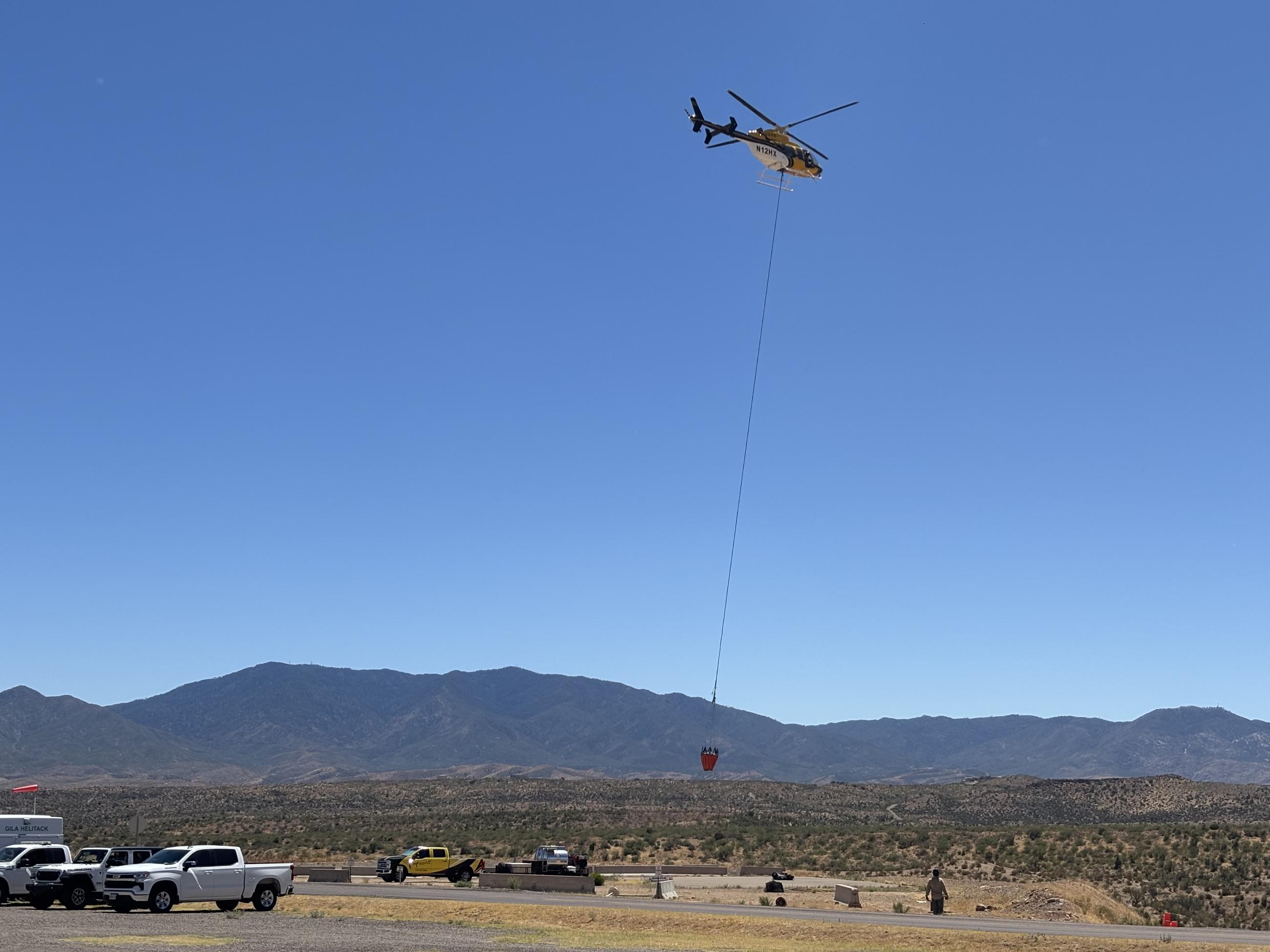 Helicopter with bucket lifting off 061926